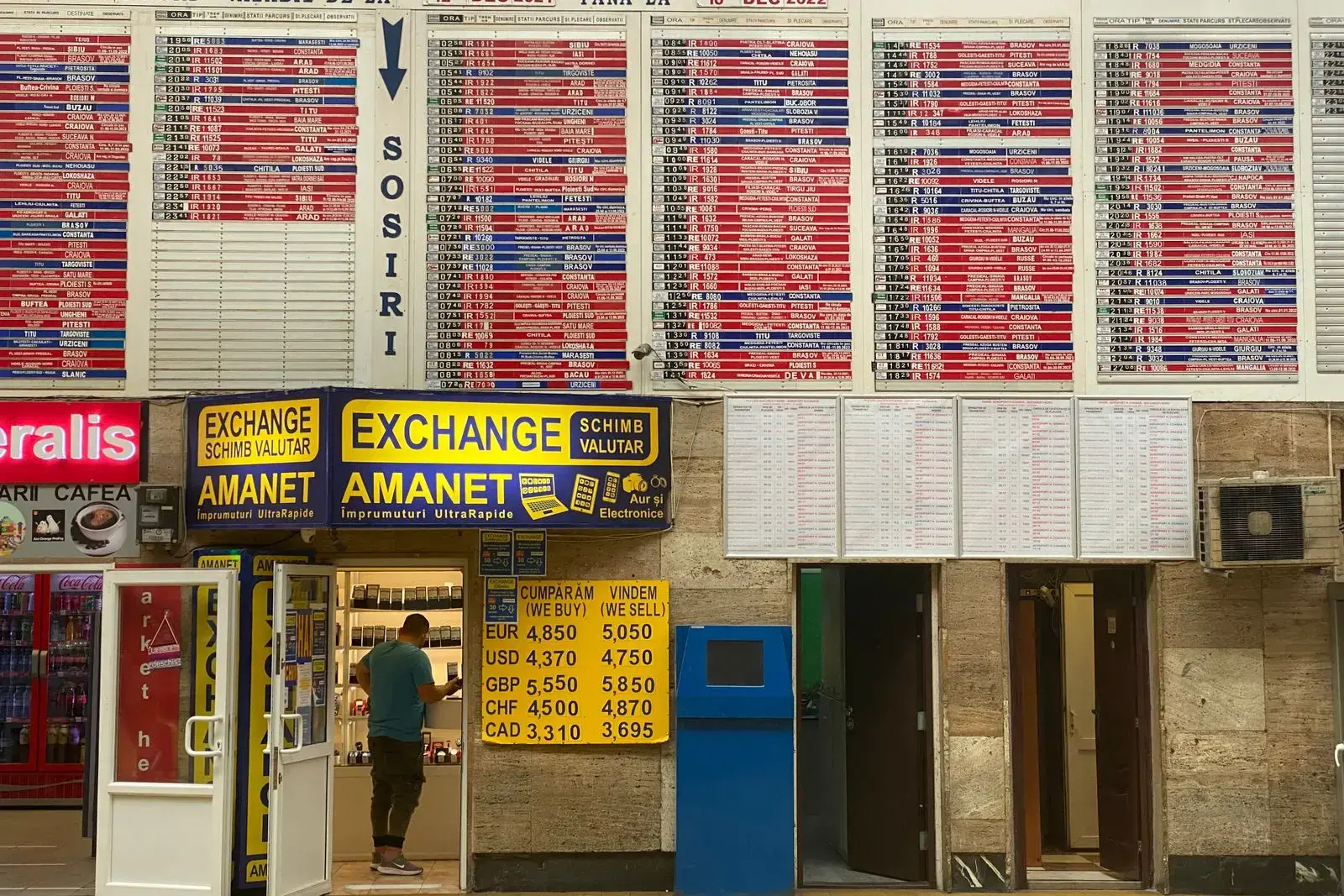 A currency exchange office with rate boards in a station concourse